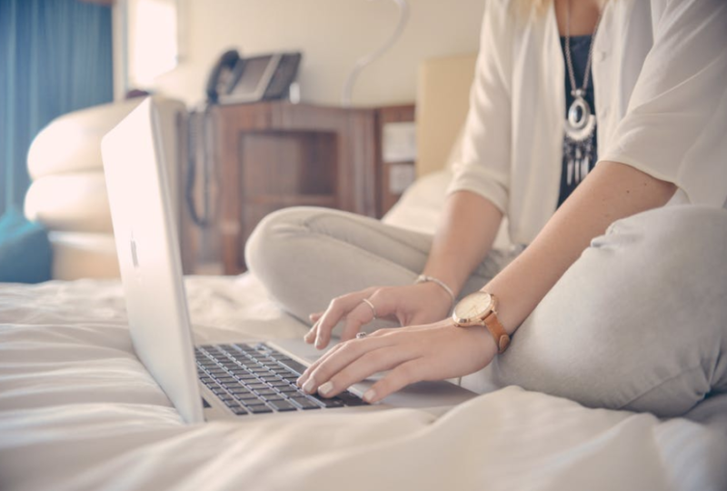 woman-sitting-on-bed-with-laptop
